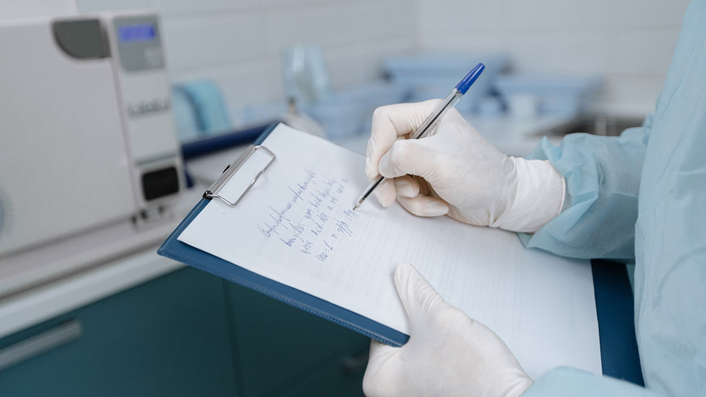 Medical professional writing a note on a clipboard